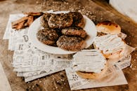 将培根放在开胃肉饼上，烤制后用于汉堡，搭配美味的金面包，置于木桌上的装饰纸，撒上芝麻