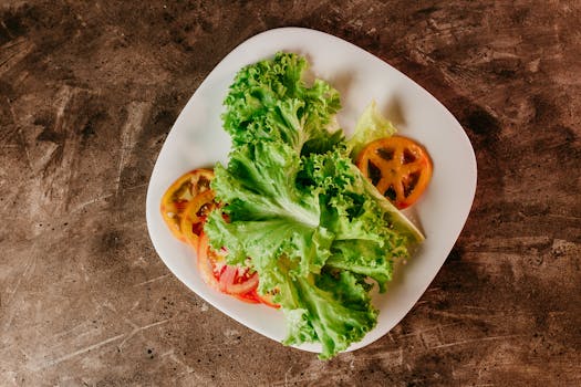 Fresh and healthy salad featuring crisp lettuce and sliced tomatoes on a rustic tabletop.