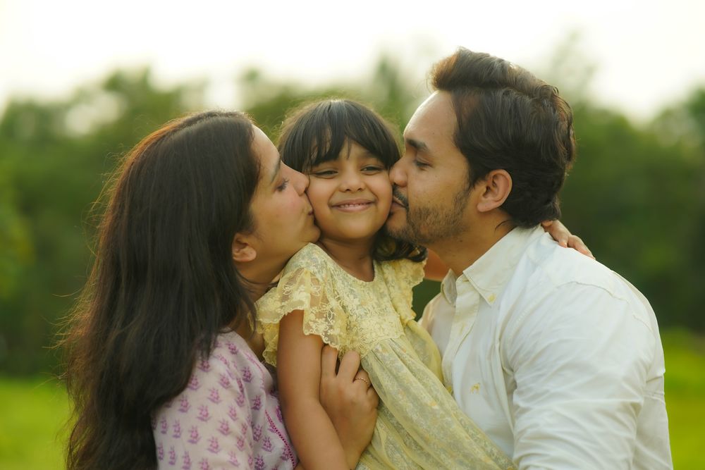 Parents hugging their smiling child — family photography