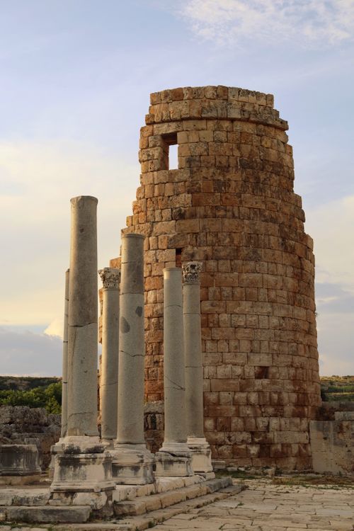 Free Captivating view of ancient Roman ruins with a towering stone structure at sunset. Stock Photo