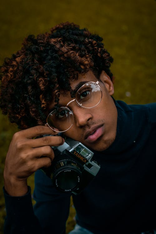 Man In Blue Long Sleeve Shirt Holding A Camera