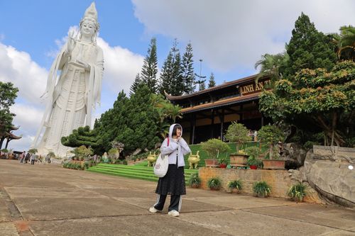 Free A serene scene at Linh An Pagoda with a giant Quan Yin statue, surrounded by lush greenery. Stock Photo