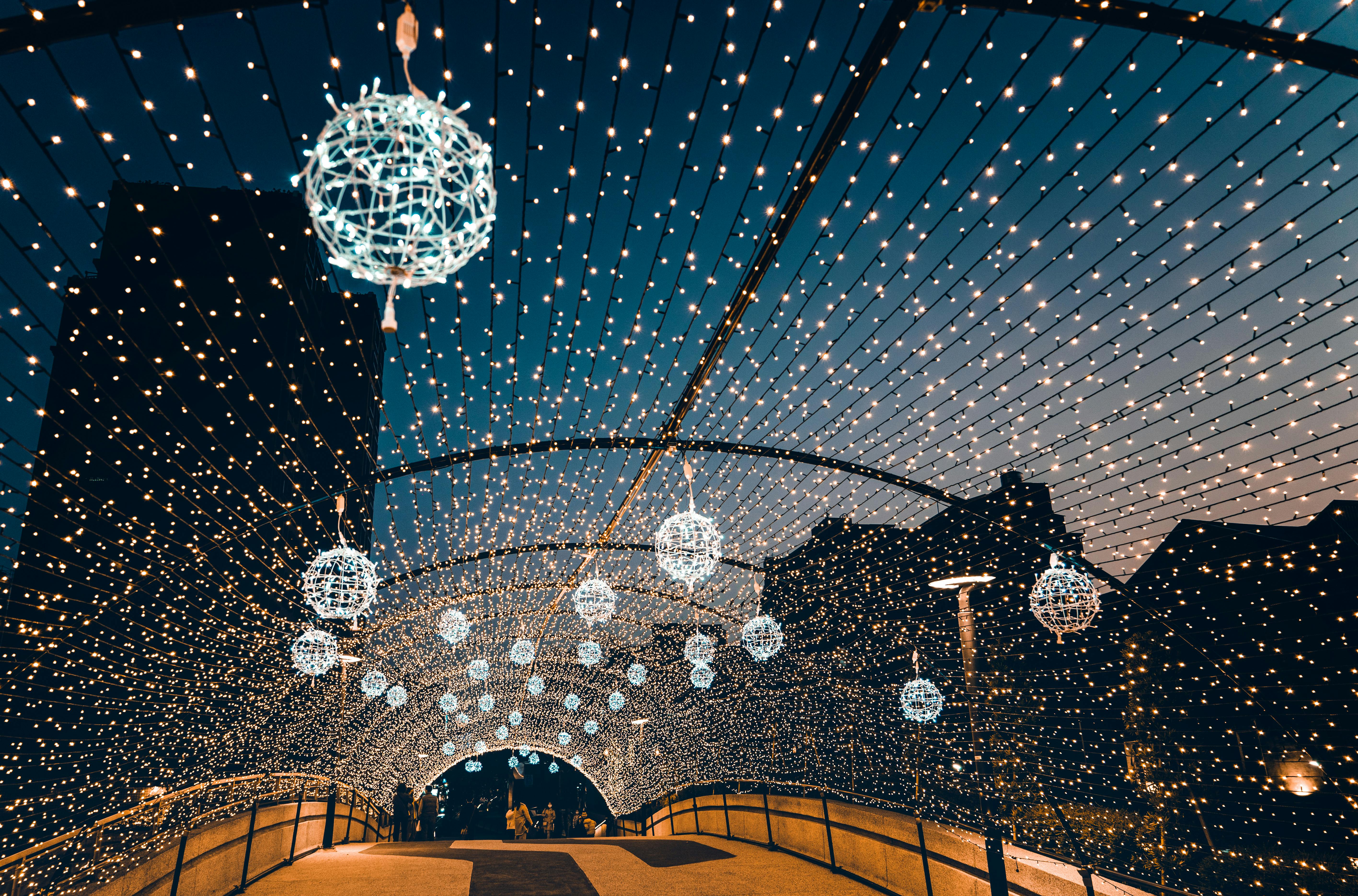 一座灯火辉煌的桥，在夜间被闪烁的弦灯装饰，营造出节日的氛围