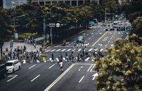 城市交叉路口的人行横道上，行人与车辆拥挤交织