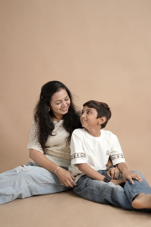 Free A joyful mother and son bonding together on a soft, neutral backdrop. Stock Photo