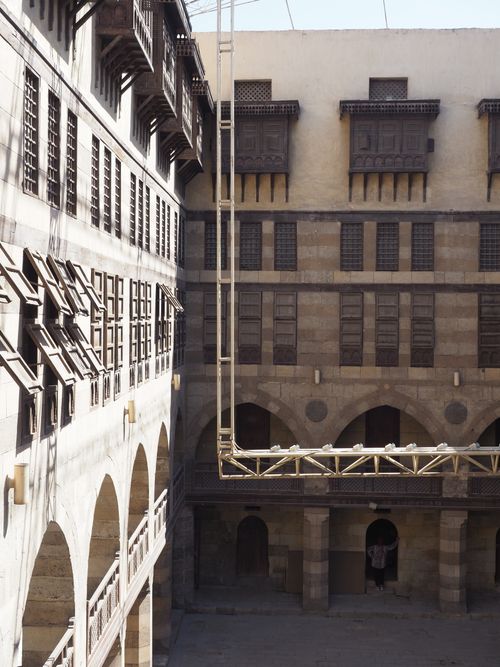 Free A historic courtyard featuring arched windows and traditional architectural design. Stock Photo