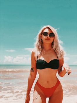 A stylish woman in a bikini enjoying a sunny day at the tropical beach in Brazil.