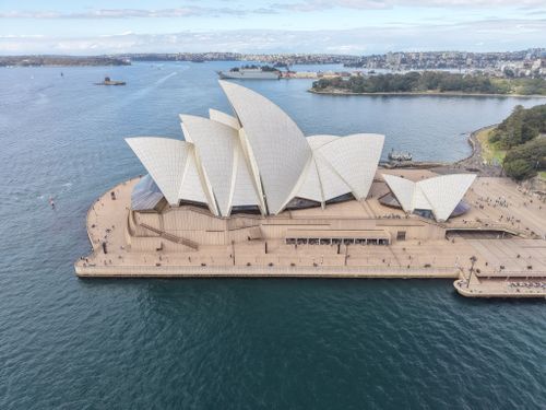 Free Iconic aerial shot of the Sydney Opera House with adjoining harbor, a landmark in Australia. Stock Photo