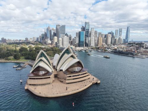 Free Aerial view of Sydney Opera House with city skyline, bright day. Stock Photo