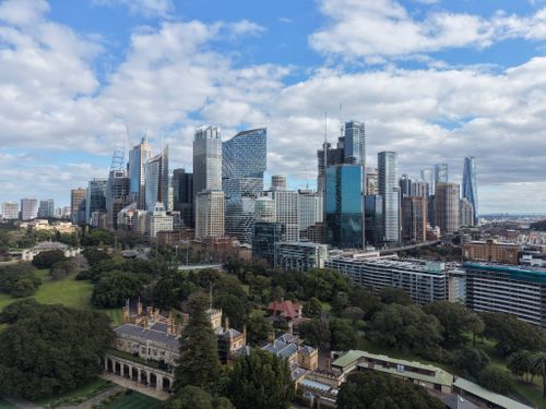 Free Aerial view of Sydney's skyline featuring lush green parks under a cloudy blue sky. Stock Photo