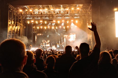 Free Energetic night concert with a cheering crowd and bright stage lights creating an electrifying atmosphere. Stock Photo