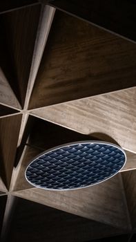 Artistic shot of a geometric architecture ceiling with a circular element, showcasing modern design.