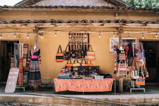 Vibrant display of ethnic clothing and crafts at Lũng Cú market, Vietnam.