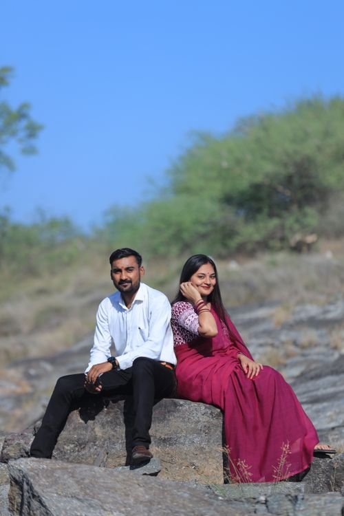 Free A couple in traditional attire poses on rocks in Dhari, Gujarat, India. Stock Photo