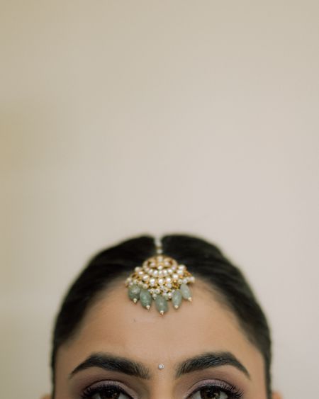 Kundan maang tikka with mint beads worn at the hairline