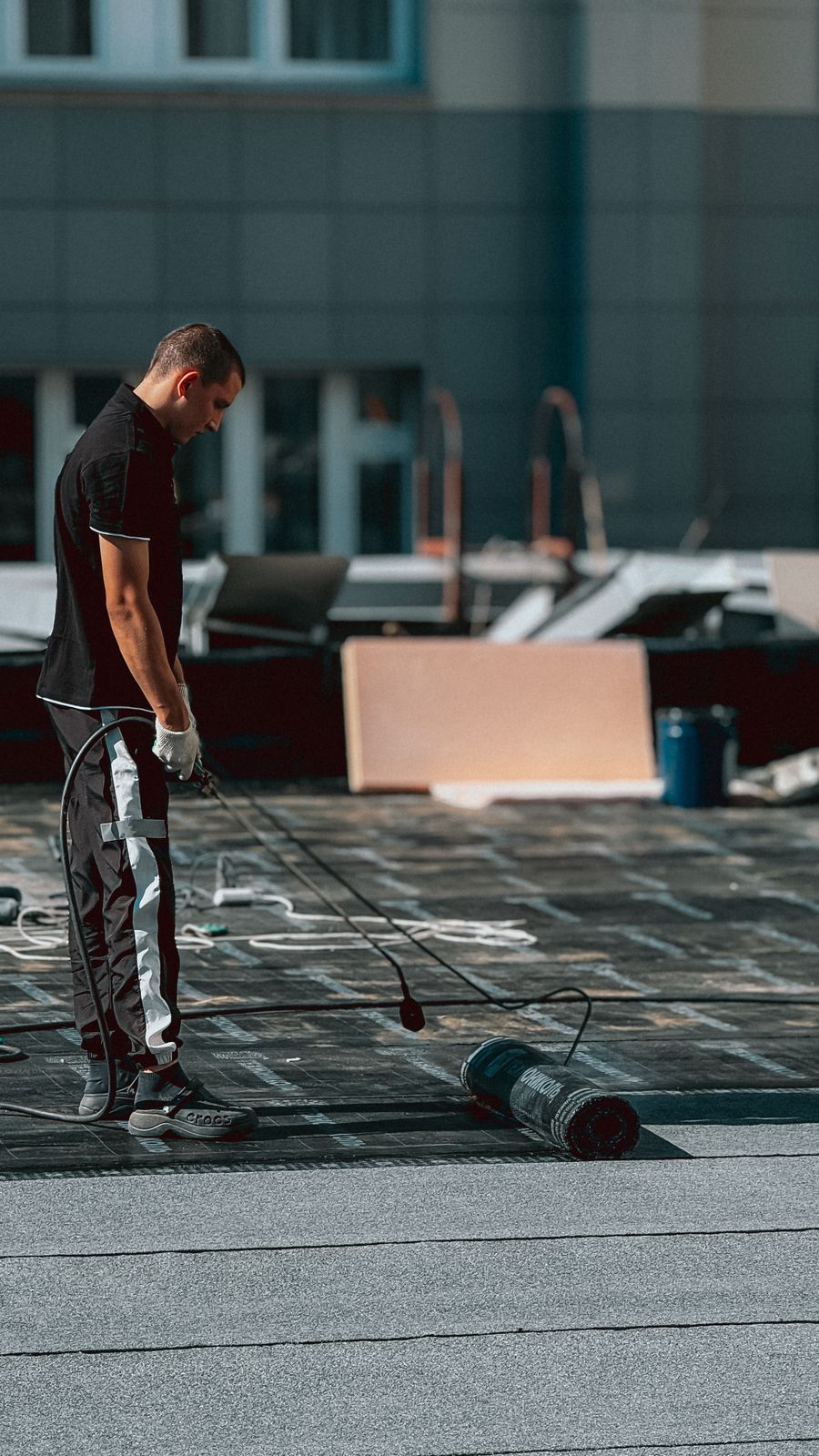 Applying waterproof coating on a rooftop with a roller