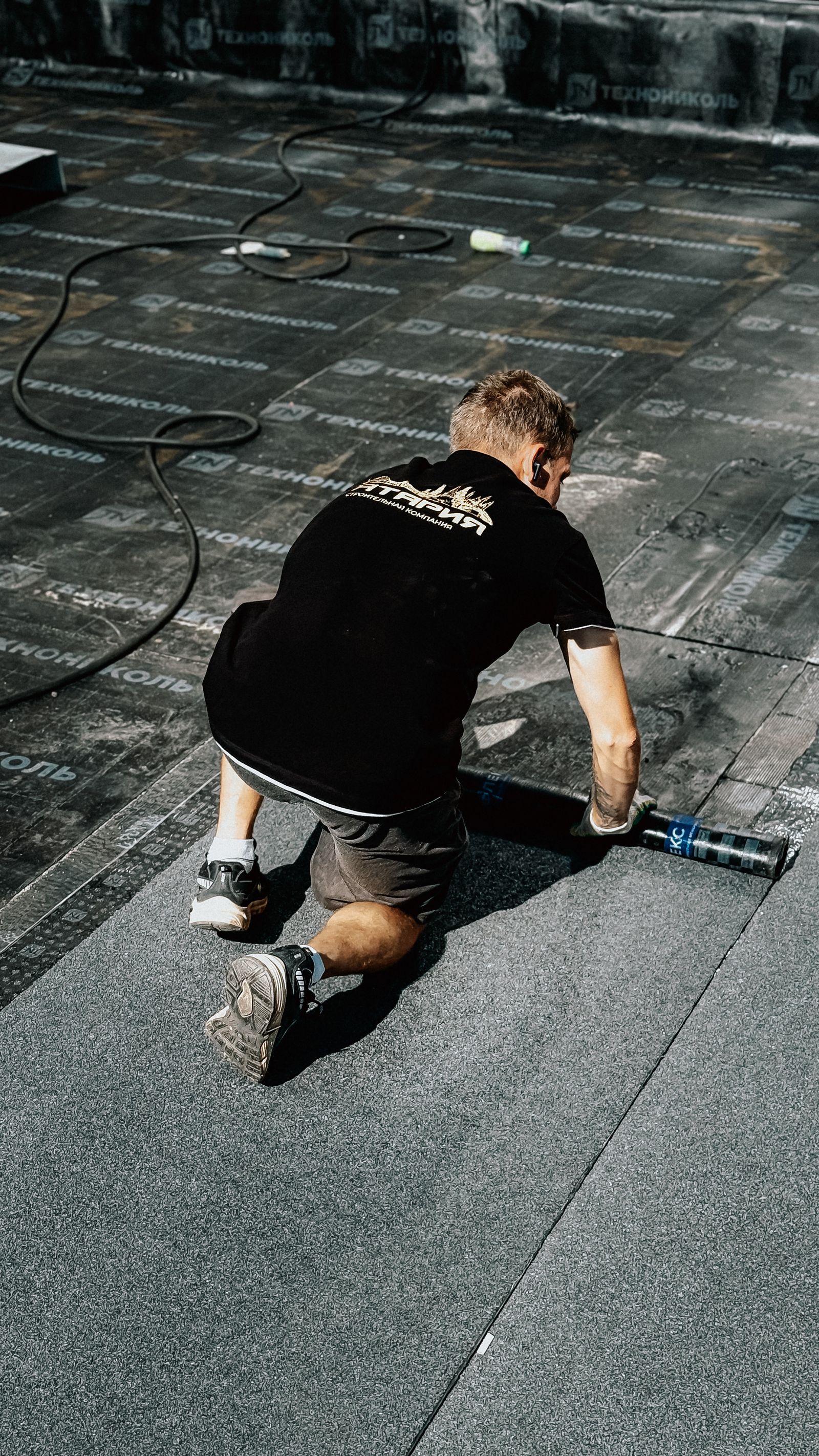 Worker installing roofing components for a larger roof drainage project
