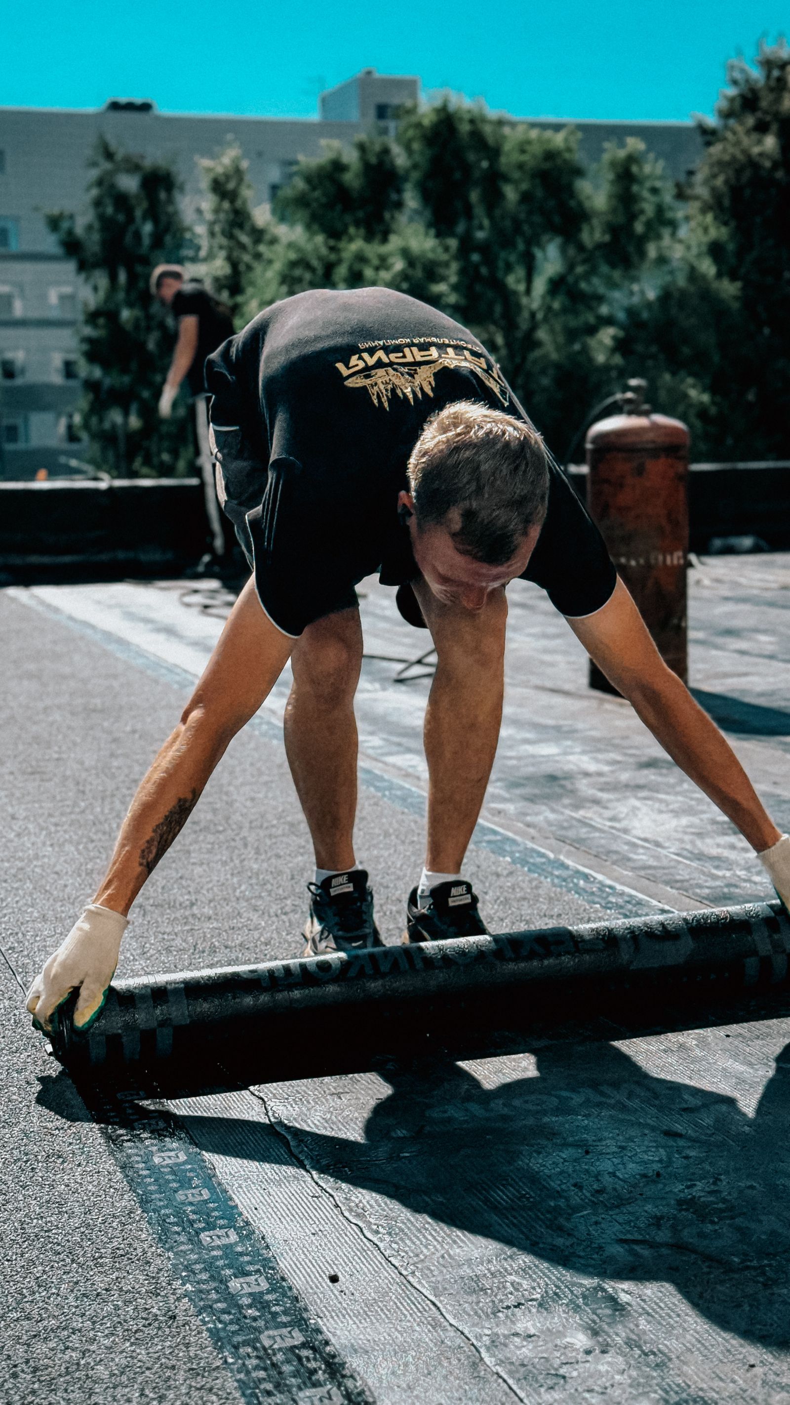 Roofer installing a single-ply membrane on a flat roof