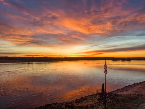 Free Stunning sunset view over the Mississippi River in Reads Landing, Minnesota with an American flag by the shore. Stock Photo