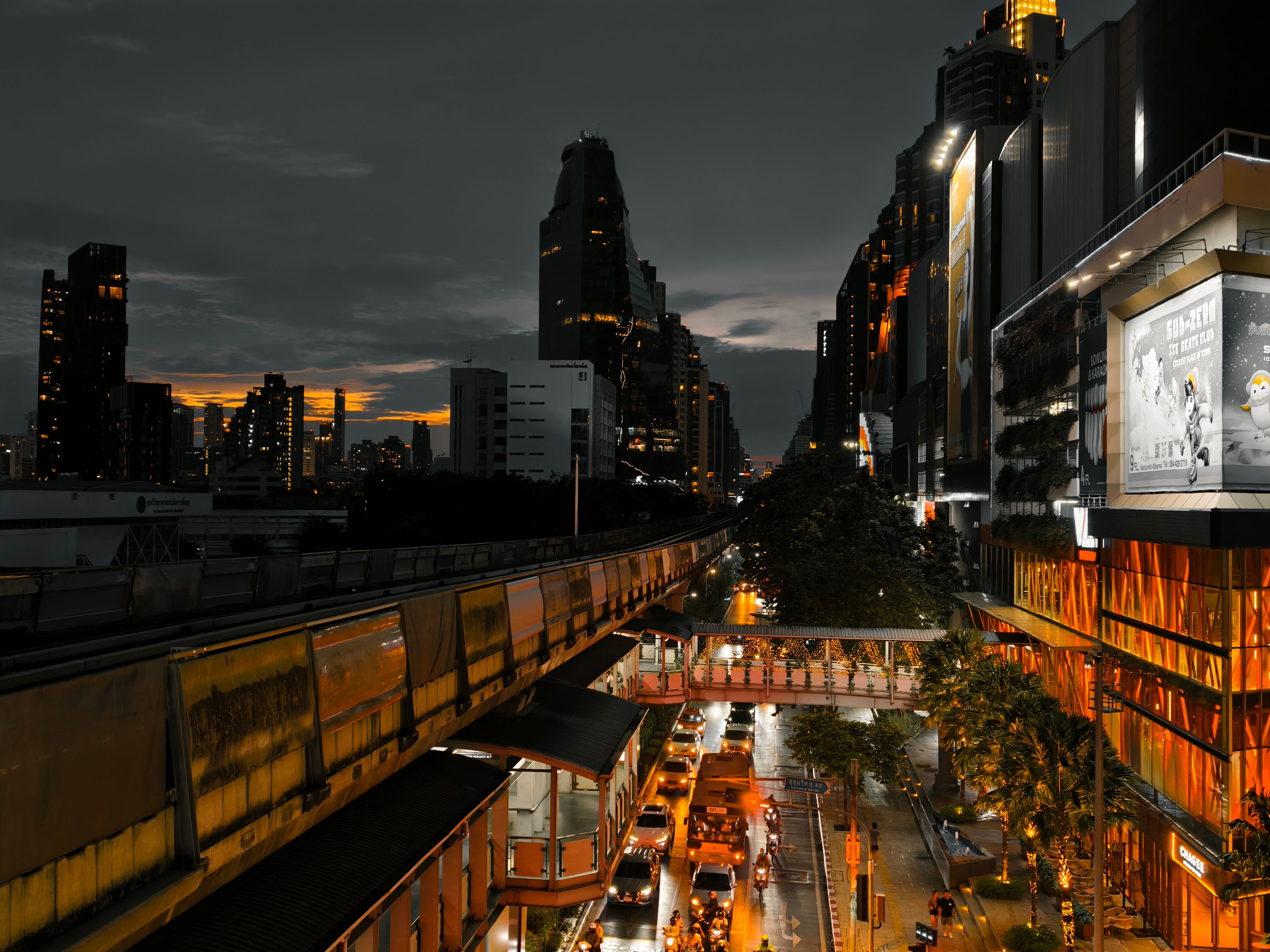 Dynamic city skyline at dusk featuring a bustling elevated train and illuminated buildings.