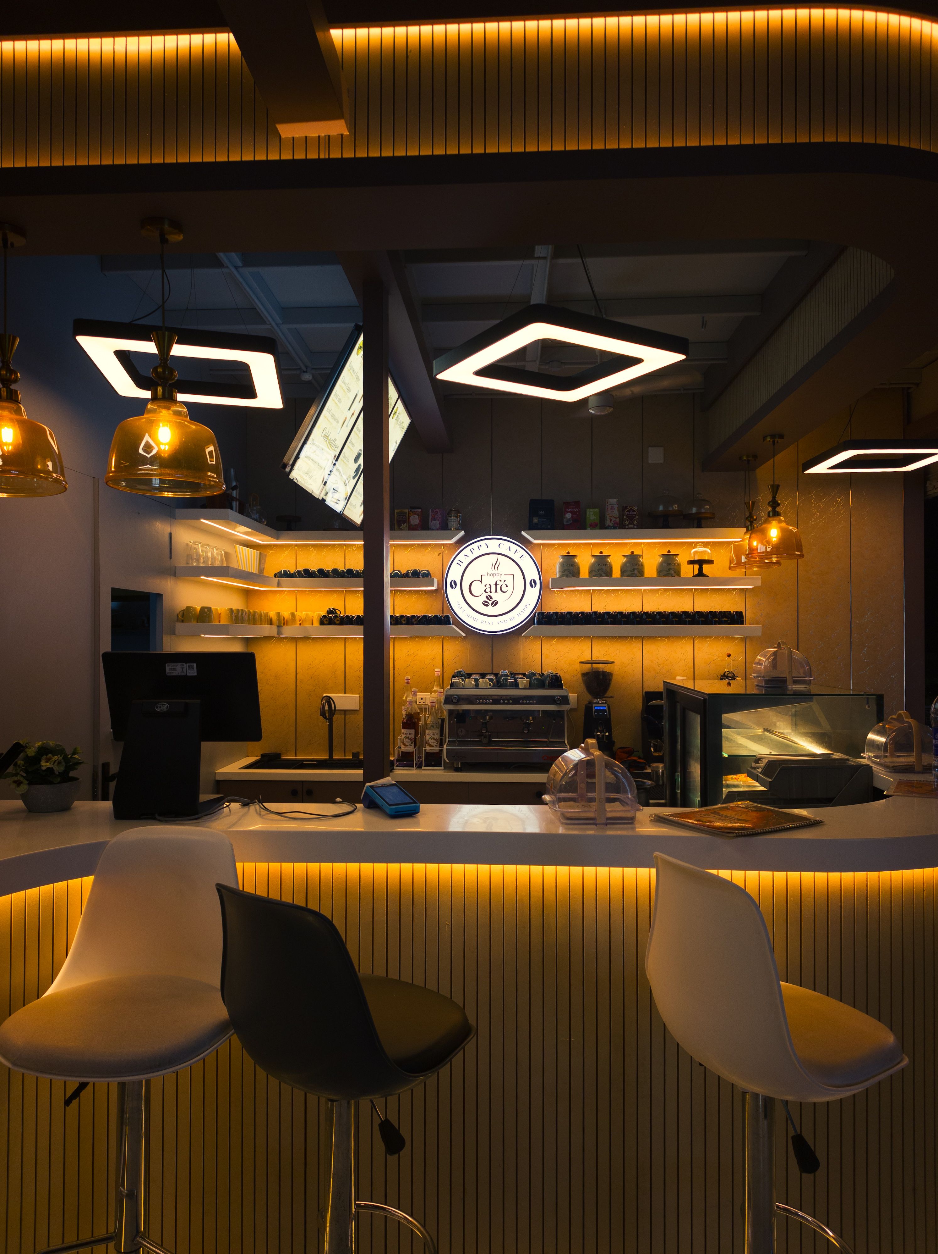 Bright under-cabinet LED strip lights illuminating a minimalist home coffee bar workspace