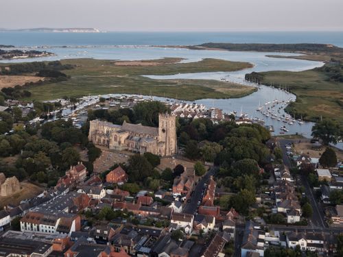 Free Stunning aerial shot of Christchurch Priory with scenic harbor and coastline views. Stock Photo