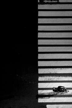 Artistic black and white photo of a shadowed urban crosswalk in New York.