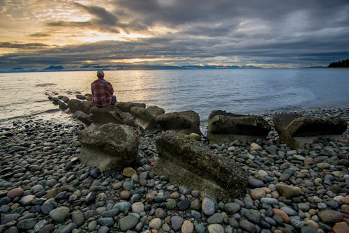 Man Sitting On A Big Rock