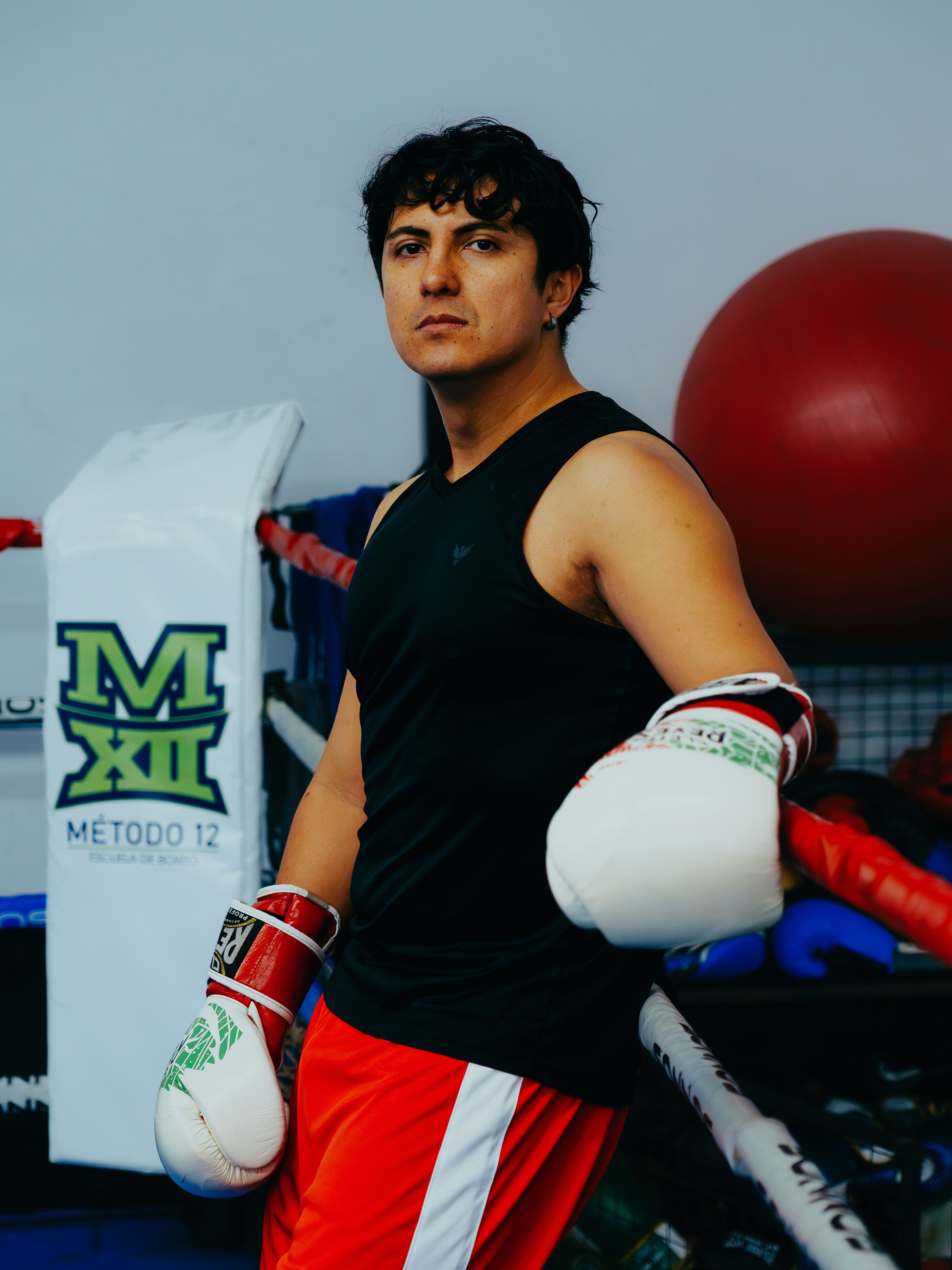 Male boxer with gloves posing in a Buenos Aires gym, ready for training.