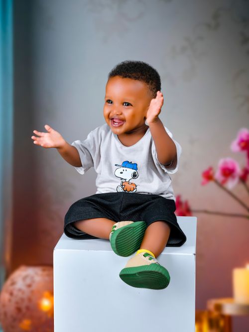 Free Adorable young child sitting indoors, smiling brightly, spreading joy and happiness. Stock Photo