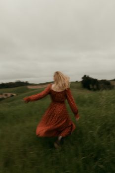 一位穿着飘逸红色裙子的女人在郁郁葱葱的绿色田野中自由奔跑。 - 相关推荐
