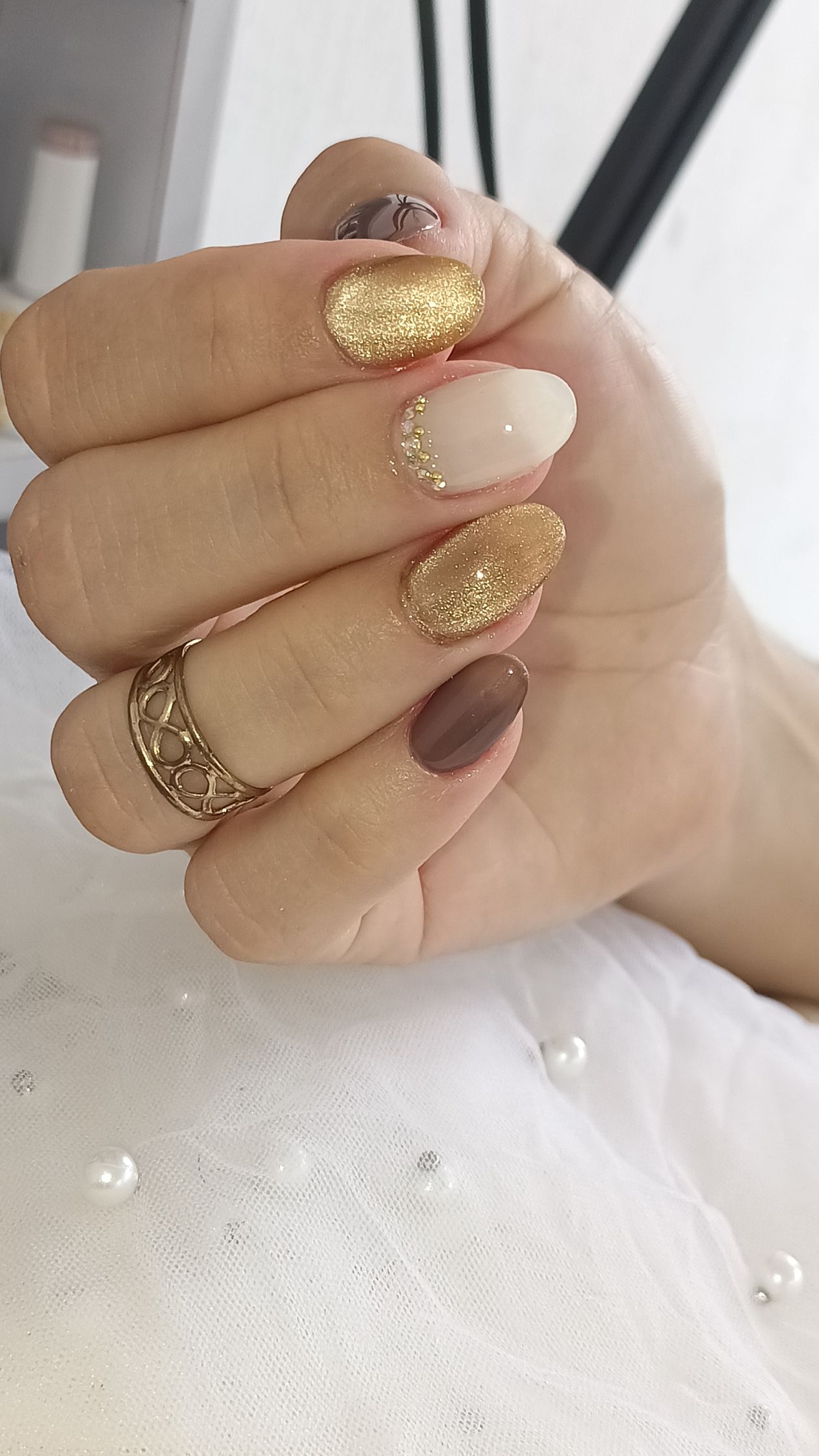 Gold chrome nail accents over milky white nails