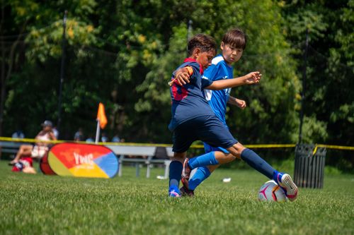 Free Two young soccer players in a heated match on a sunny day in a New York park. Stock Photo