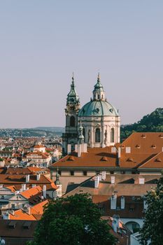 A stunning view of St. Nicholas Church with Prague's vibrant skyline under clear skies.