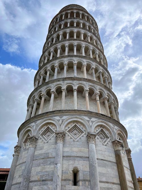 Free Iconic Leaning Tower of Pisa, Italy viewed from below against a cloudy sky. Stock Photo