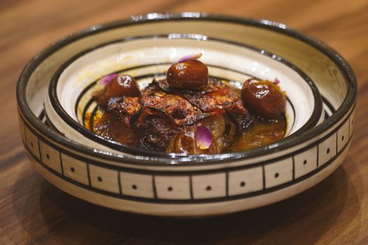Delicious Moroccan tagine with dates served in an artisanal bowl, showcasing vibrant flavors of Essaouira, Morocco.