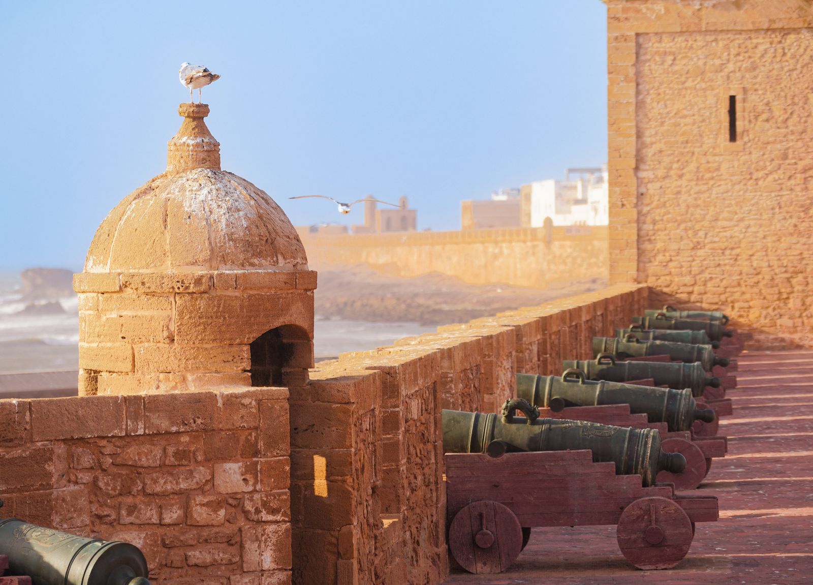 Guide voyage Essaouira 2026 — bateaux de peche bleus dans le port avec les remparts de la Skala du 18e siecle