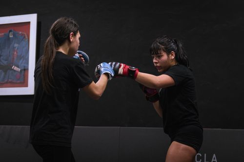 Free Two women practice boxing techniques in a gym, focusing intently. Stock Photo