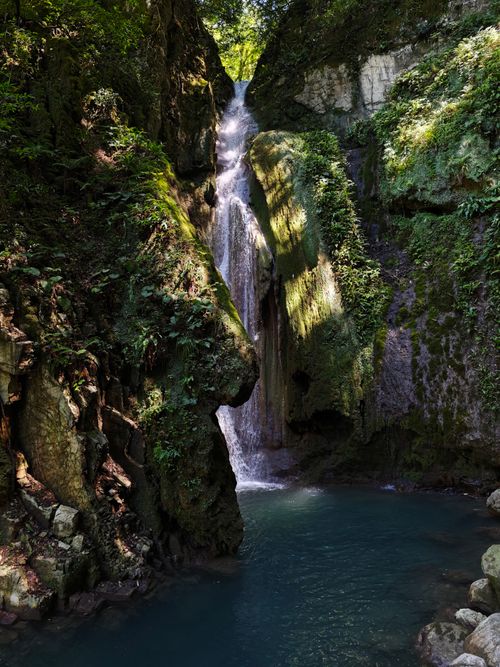 Free A tranquil waterfall surrounded by lush greenery, captured in daylight. Stock Photo