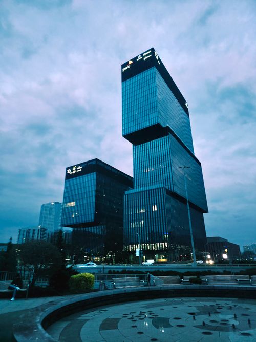 Free Tall glass skyscrapers stand elegantly under a cloudy twilight sky, showcasing modern architecture. Stock Photo