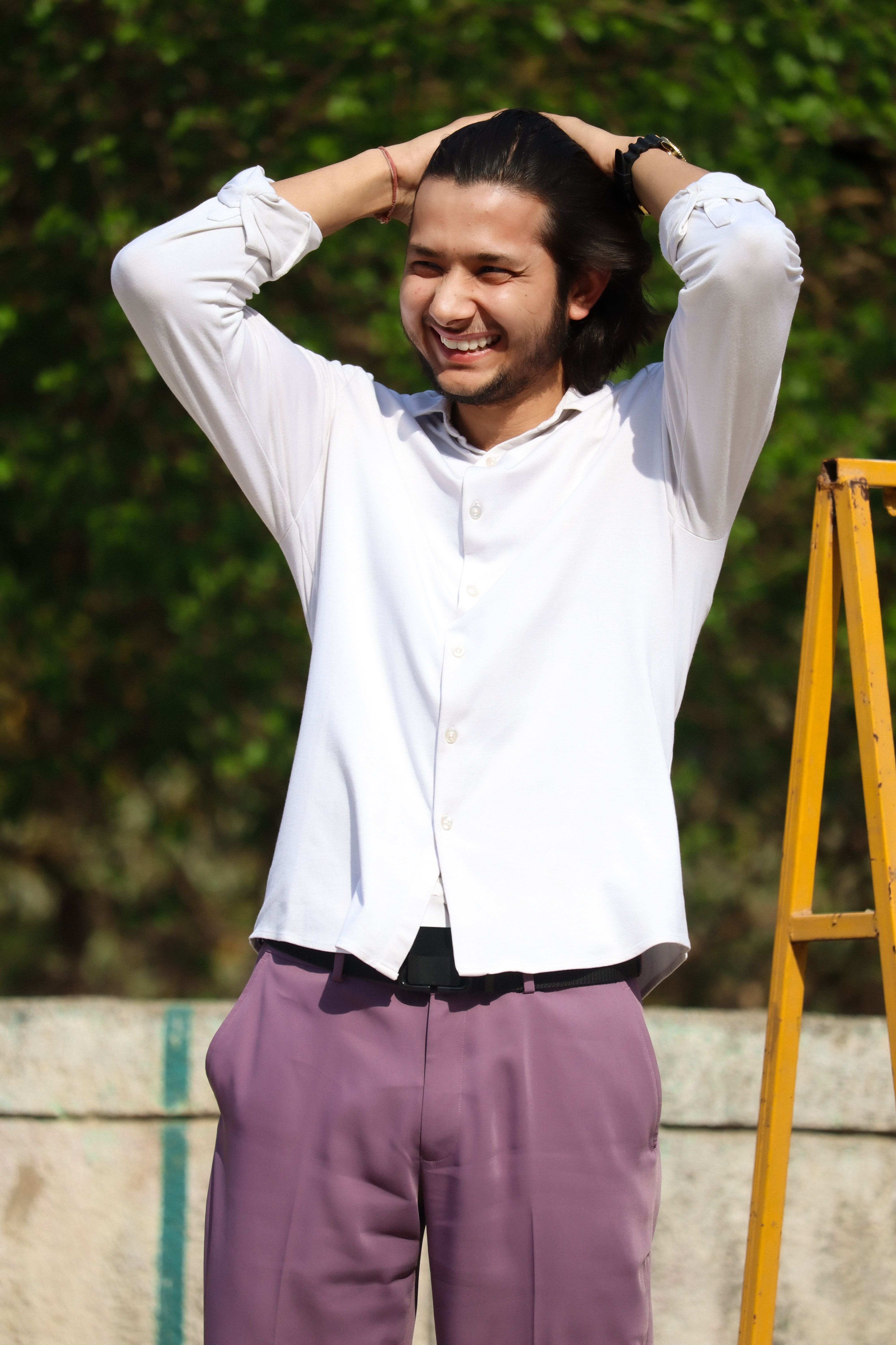Happy young man enjoying a sunny day outdoors, dressed in casual attire. Perfect for lifestyle and travel concepts.