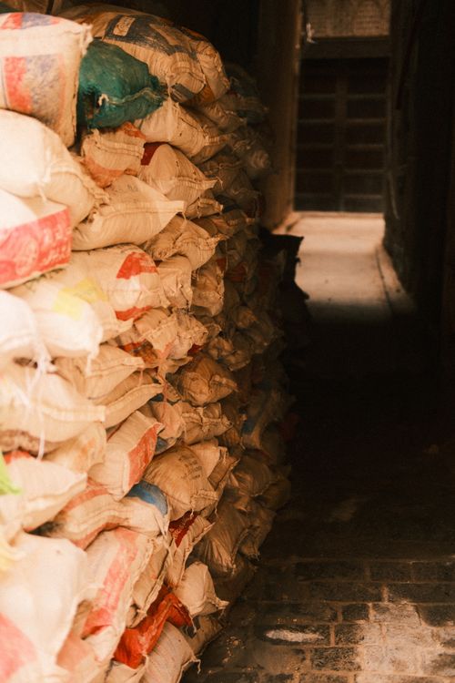 Free Stacked multi-colored bags in a narrow alleyway in Fes, Morocco, captured in warm tones. Stock Photo