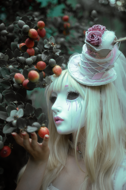 Free A dreamy, surreal portrait of a masked figure in a whimsical, enchanted forest with berries. Stock Photo