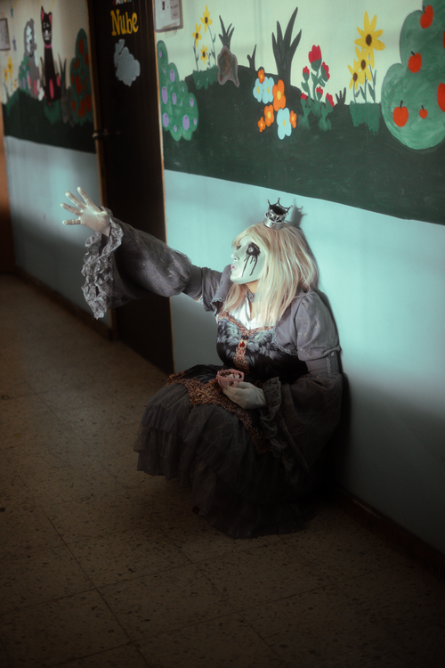 Free Conceptual portrait of a costumed figure with gothic fashion in a dimly lit hallway. Stock Photo