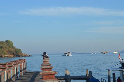 Free Photographer captures calm sea view from a wooden pier under a clear blue sky. Stock Photo