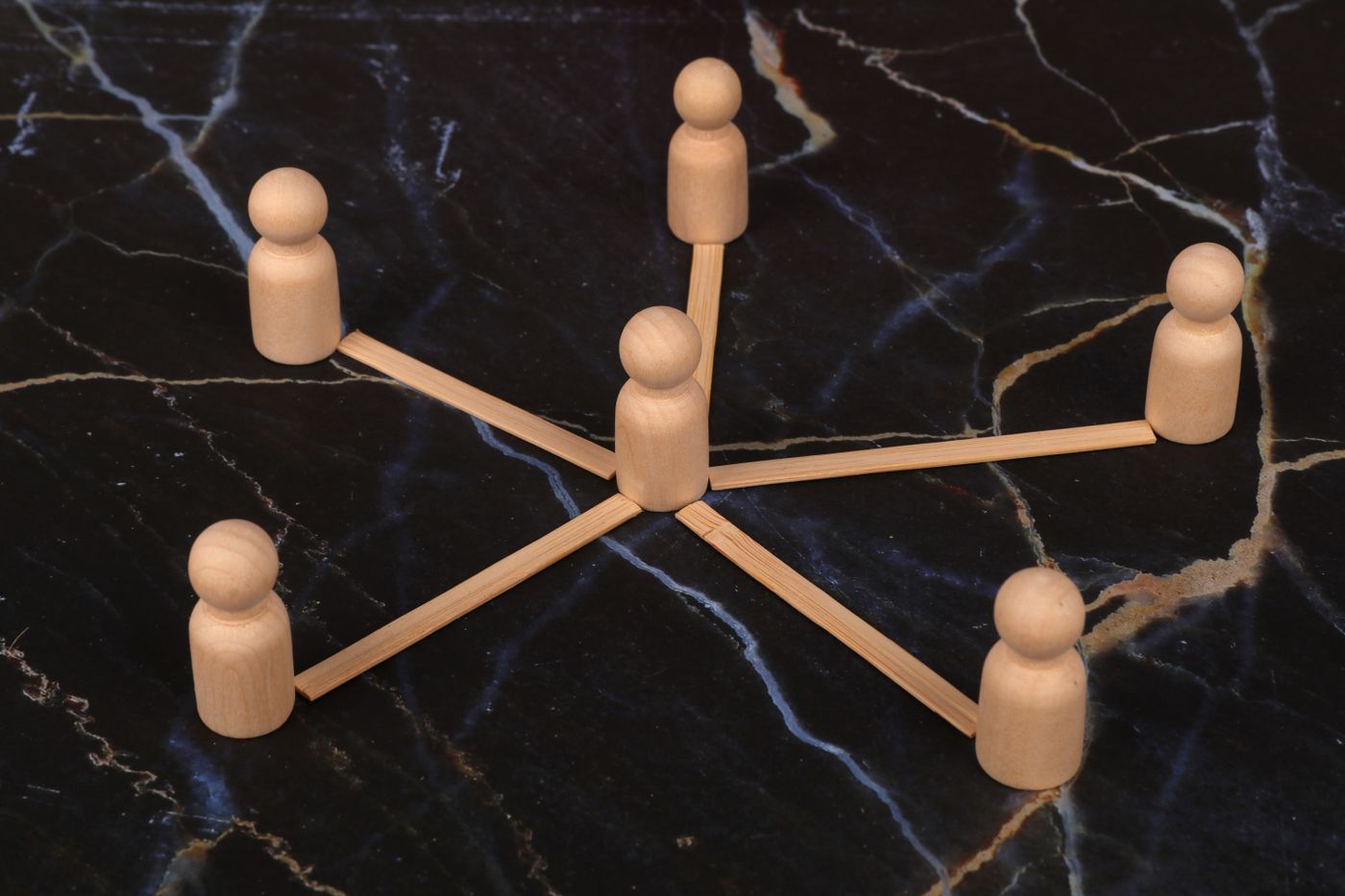 Wooden figures linked in a network diagram