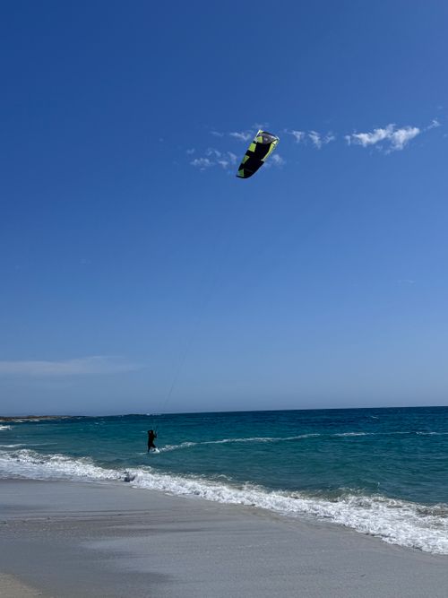 Free A kitesurfer rides the waves on a sunny day at a beautiful beach in Sardinia, Italy. Stock Photo