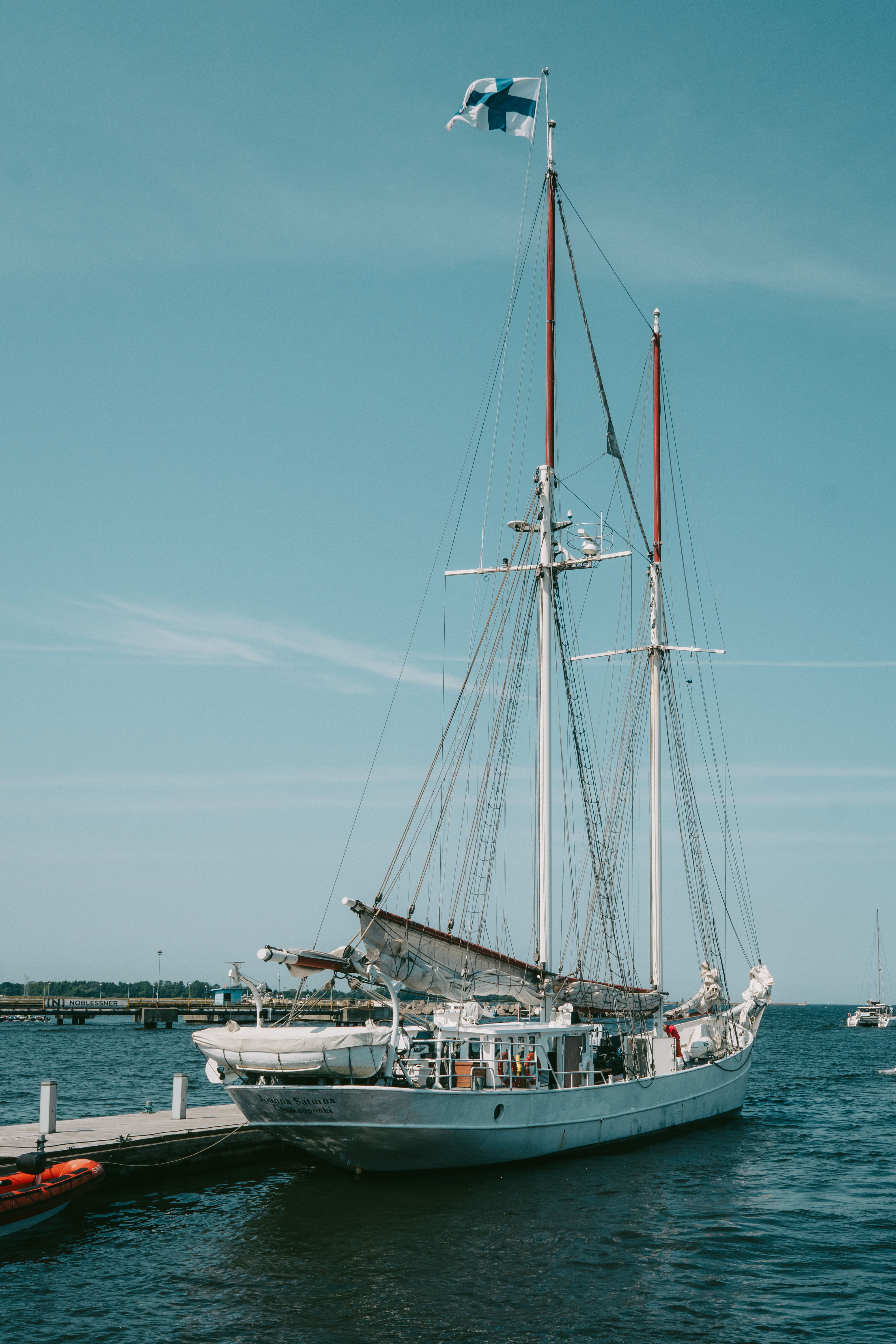 A classic sailing ship docked at a marina in Tallinn, Estonia, under a clear summer sky.
