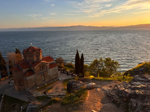 Free Serene sunset view over Ohrid Lake and Church of St. John at Kaneo, Macedonia. Stock Photo