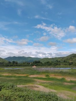 Peaceful view of green hills and a bright blue sky with scattered clouds. - Fotografer Sidoarjo